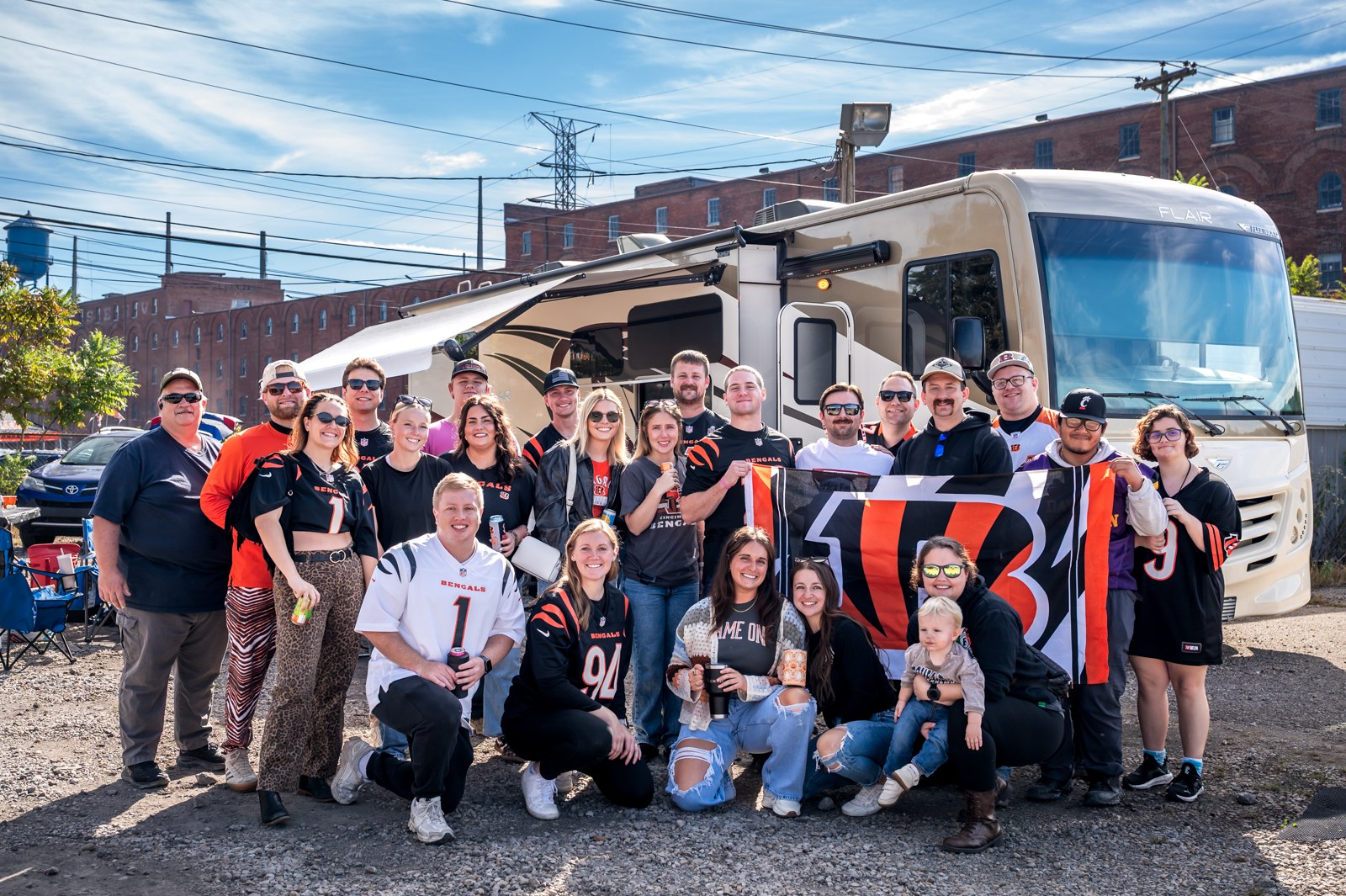 Bengals fans in orange and black posing together beside a large RV.