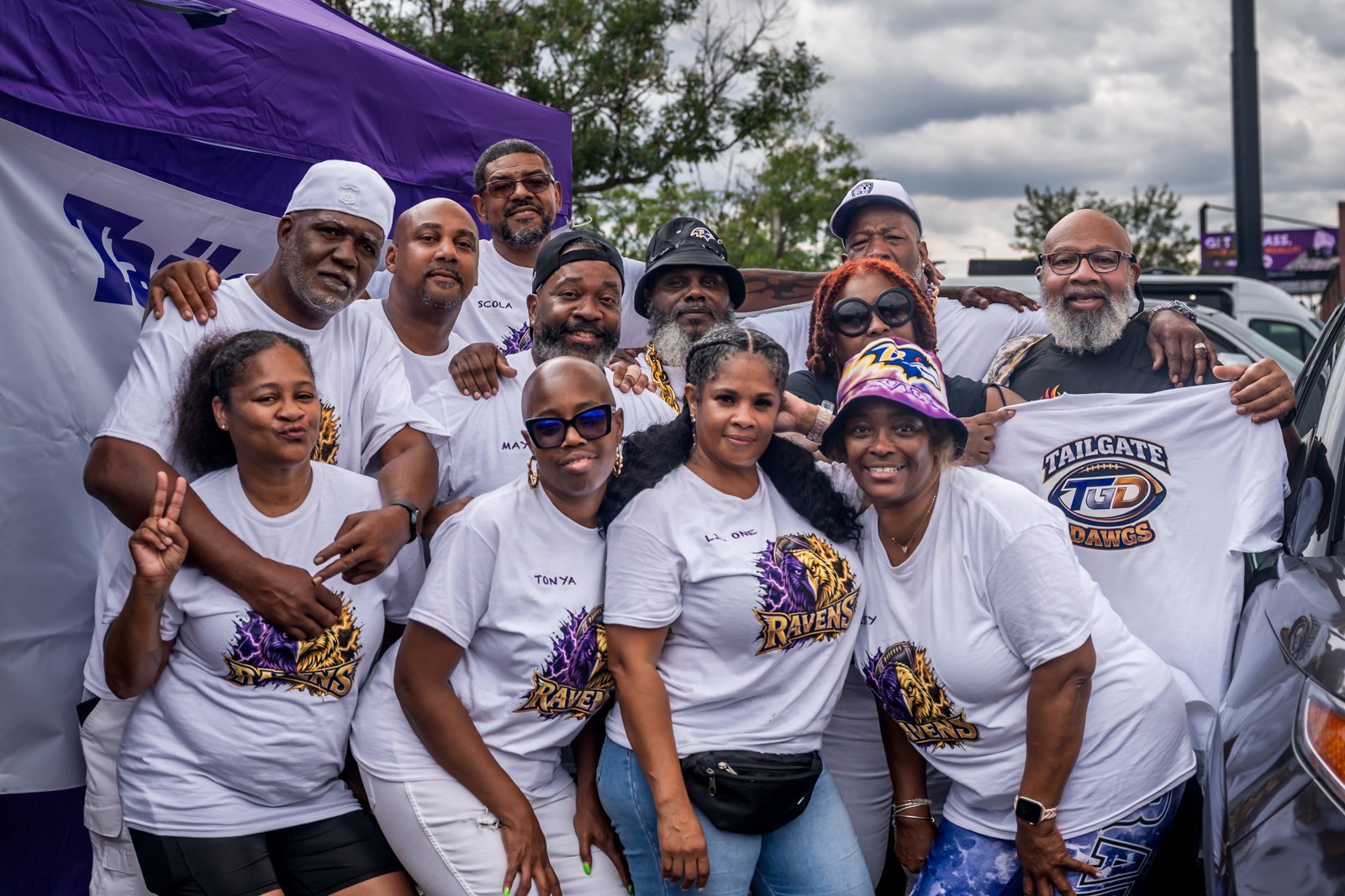 Ravens tailgate group in purple and white gathered in front of their tent.